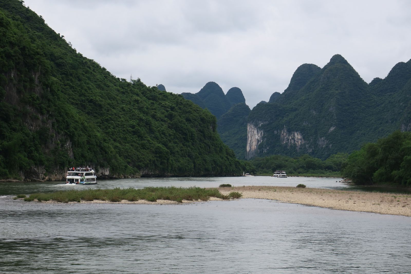 Sightseeing riverboat on the Li River between green karst peaks near Guilin, China, one of the regional waterways sailed by river cruise lines in Asia